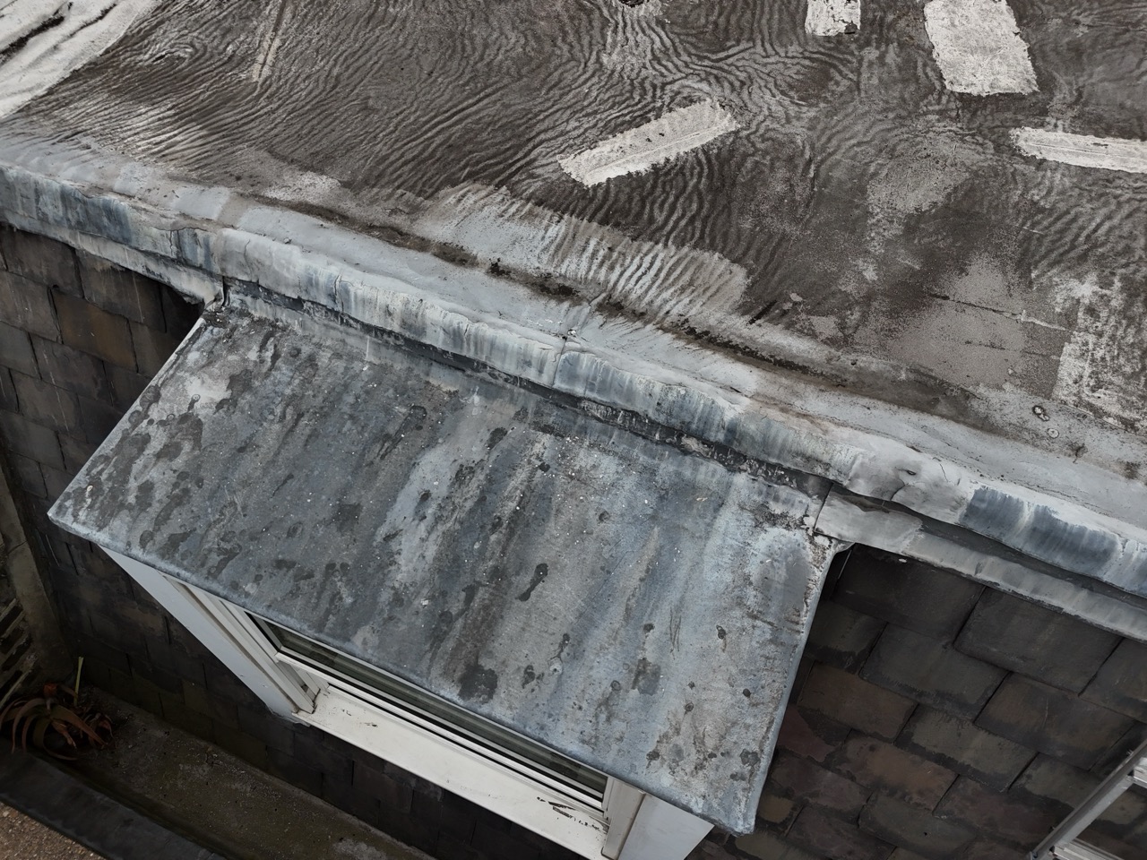 Close-up drone photograph of commercial flat roof membrane showing wear patterns and potential failure points